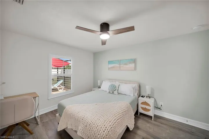 Bedroom featuring wood finished floors, a ceiling fan, visible vents, and baseboards