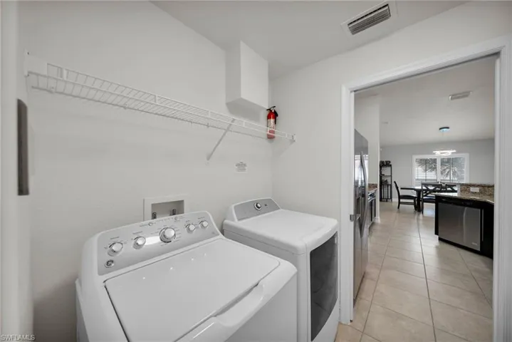 Laundry room featuring visible vents, light tile patterned flooring, laundry area, and independent washer and dryer
