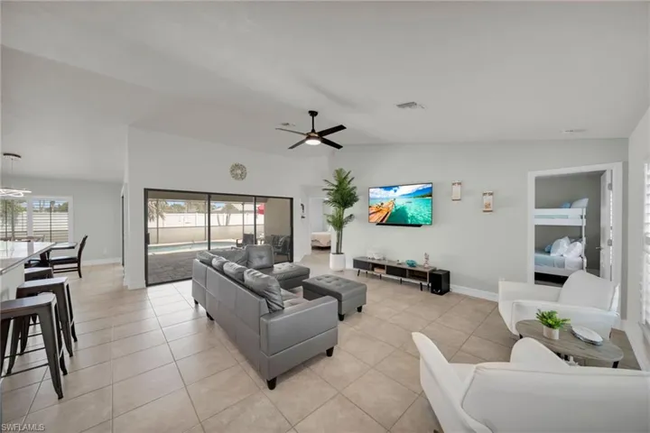 Living area with baseboards, a ceiling fan, and light tile patterned flooring