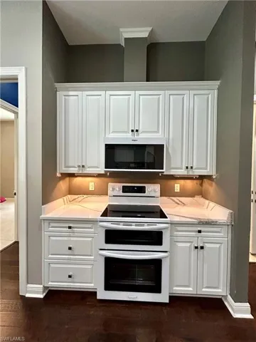 Stunning white custom kitchen cabinets have so much storage and extras behind every drawer & door!