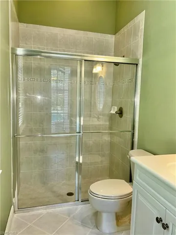 Pool bath has a large shower with glass doors, tile walls & is also connected to a bedroom