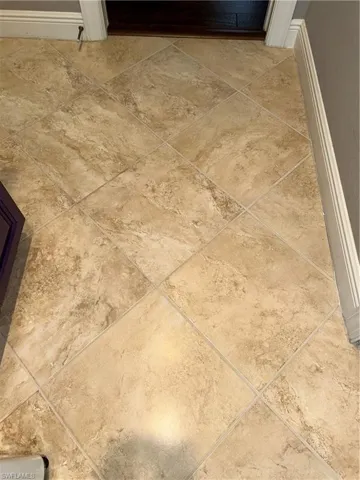 Floor in laundry room has hues of light tans & browns.