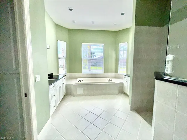 Master bathroom Jacuzzi L1 whirlpool tub, large tub deck, double split vanities with black quartz and a walk-in shower with double heads.