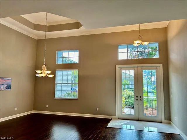 Coffered ceilings, transom windows over doors & window flood the dining area. Wood floors again and a marble herringbone laid pattern foyer elevate the room with  a subtle touch and the veining matches the color on the walls.