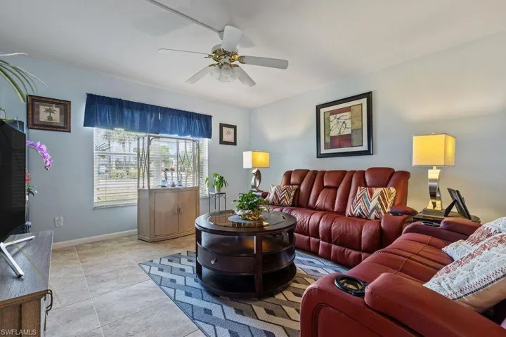Living room with ceiling fan and light tile flooring