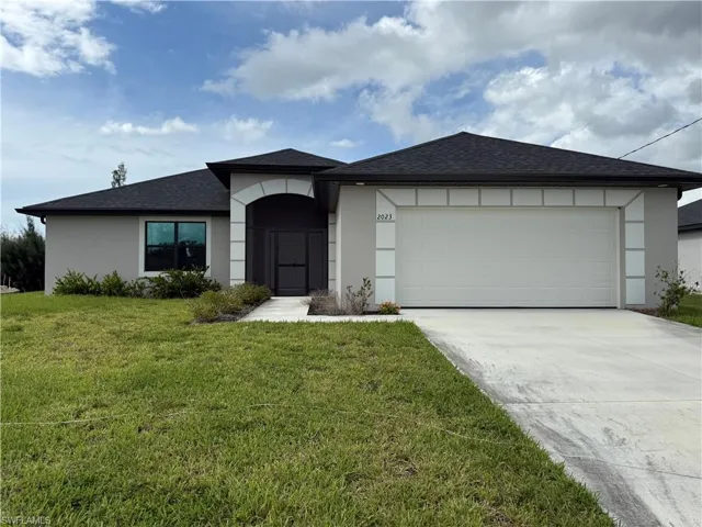Ranch-style home with stucco siding, roof with shingles, a front lawn, and driveway