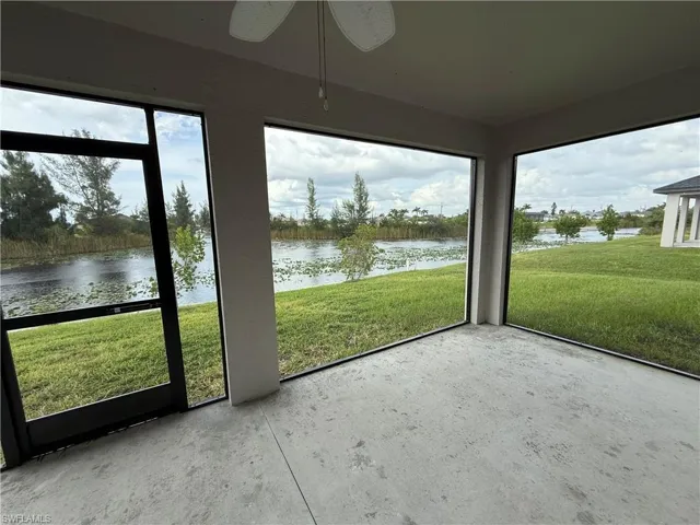 Unfurnished sunroom featuring a water view and a ceiling fan