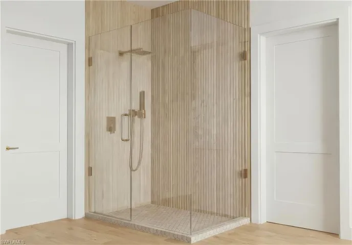 Bathroom with a shower stall and light wood-style floors - Virtually Edited