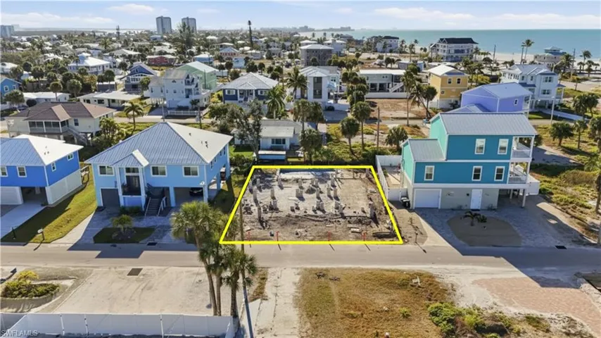 Aerial perspective of suburban area with property parcel outlined and a nearby body of water - Virtually Edited Image