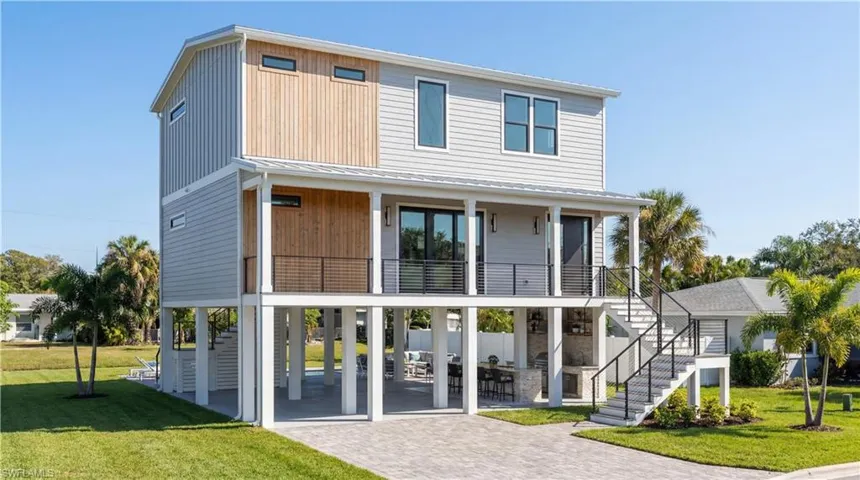 Rear view of house featuring a yard, a patio, a metal roof, and driveway - Virtual Rendering