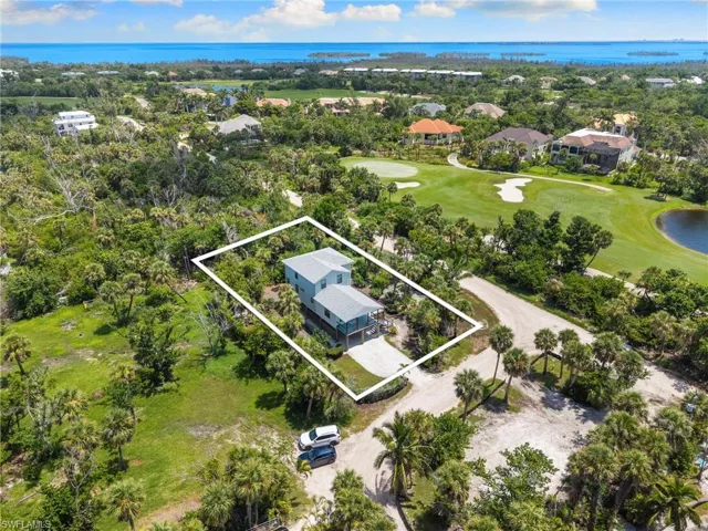 Aerial perspective of suburban area featuring a nearby body of water, property parcel outlined, and a local golf course