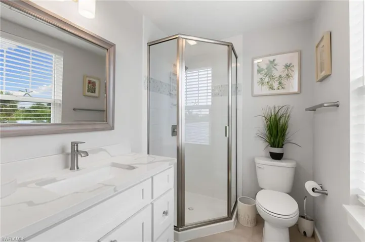 Full bathroom with vanity, a stall shower, and light tile patterned floors