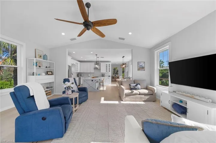 Living room featuring vaulted ceiling, light wood-style flooring, a ceiling fan, and recessed lighting
