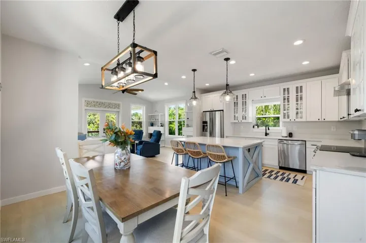 Dining area with healthy amount of natural light, light wood-style flooring, recessed lighting, lofted ceiling, and french doors