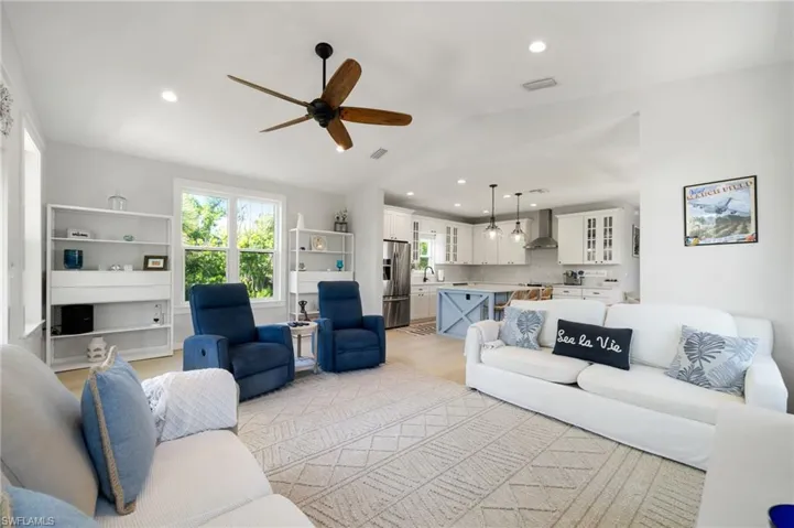 Living area with a ceiling fan, lofted ceiling, and recessed lighting
