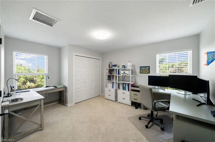 Office area featuring light colored carpet and a textured ceiling
