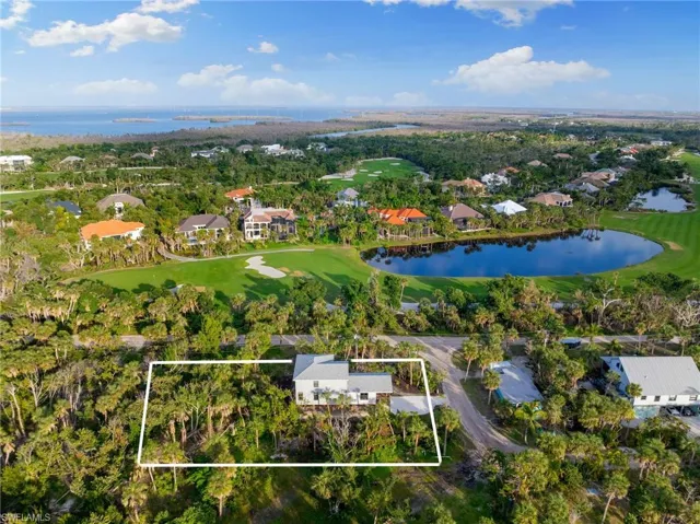 Aerial perspective of suburban area with a nearby body of water and property parcel outlined