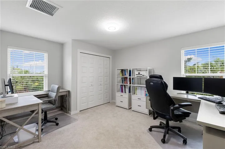Office area with light colored carpet and a textured ceiling