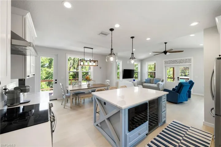 Kitchen with electric range oven, recessed lighting, pendant lighting, open floor plan, and freestanding refrigerator