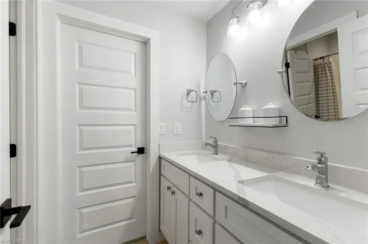 Full bath featuring double vanity and a shower with shower curtain