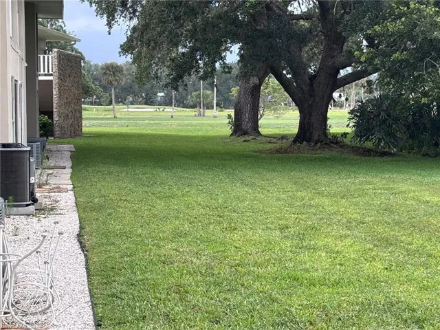 View of grassy yard featuring central air condition unit