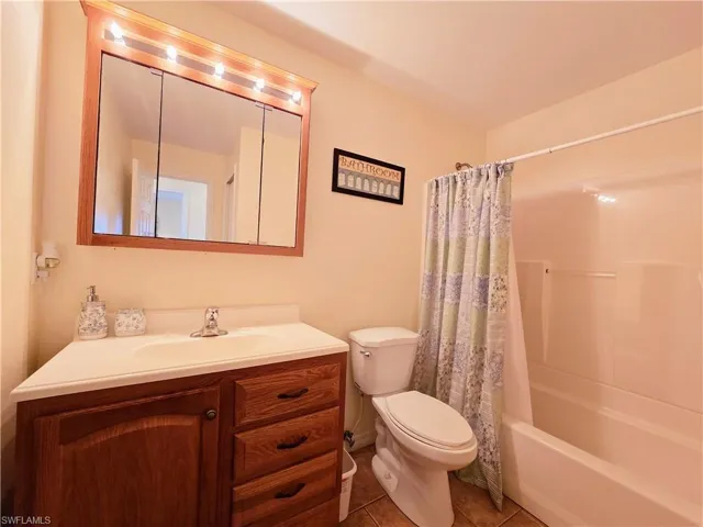 Full bathroom featuring tile patterned flooring, vanity, toilet, and shower / bath combo