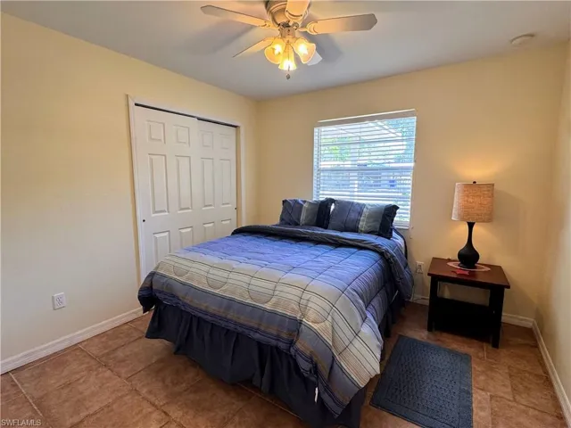 Bedroom featuring ceiling fan, a closet, and baseboards