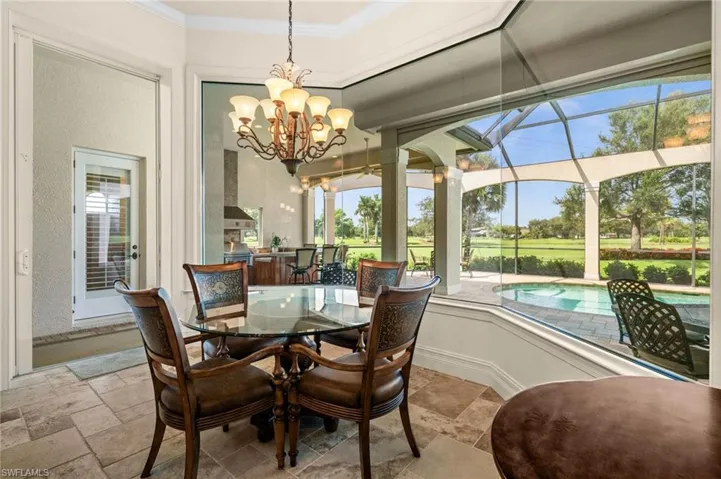 Sunlit morning room with expansive windows showcasing beautiful pool, lanai, and golf course views.