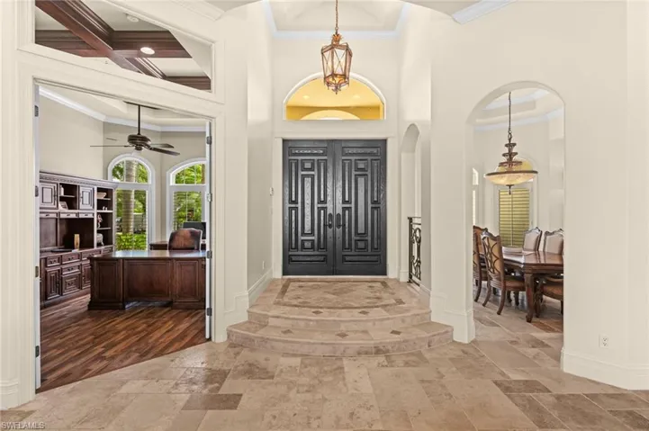 Grand foyer featuring double entry doors and elegant architectural details