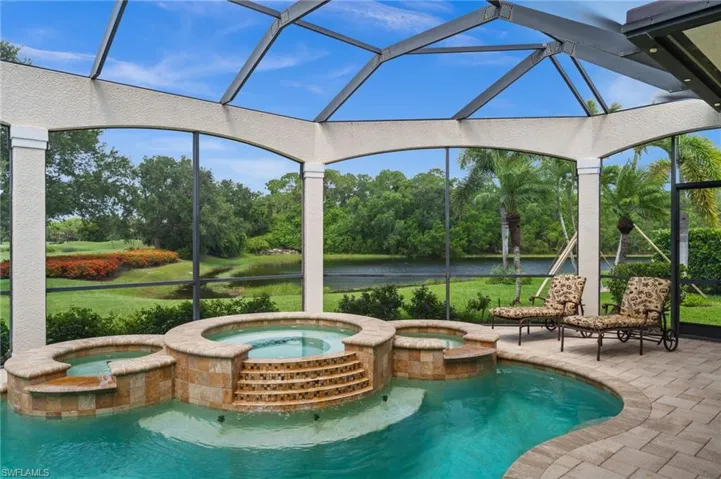 Sparkling saltwater pool and spa with decorative fountains, surrounded by panoramic golf course and lake views.