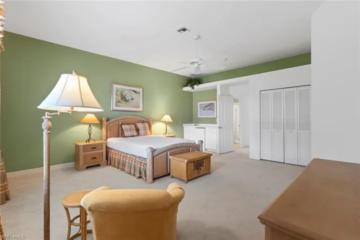 Carpeted bedroom with a closet and ceiling fan