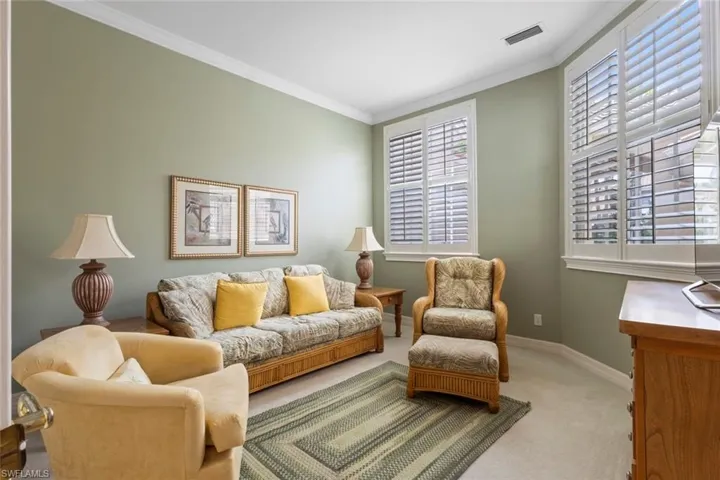 Living room featuring carpet, plenty of natural light, baseboards, and ornamental molding