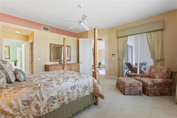 Bedroom with light colored carpet, a ceiling fan, and access to exterior