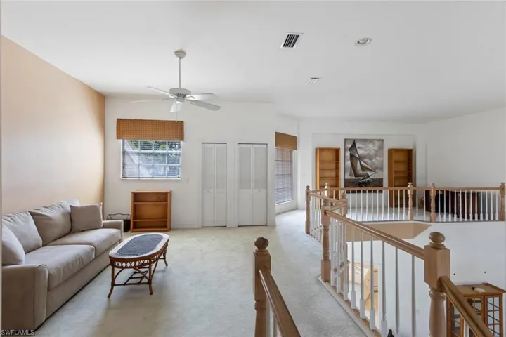 Living room with ceiling fan and light carpet