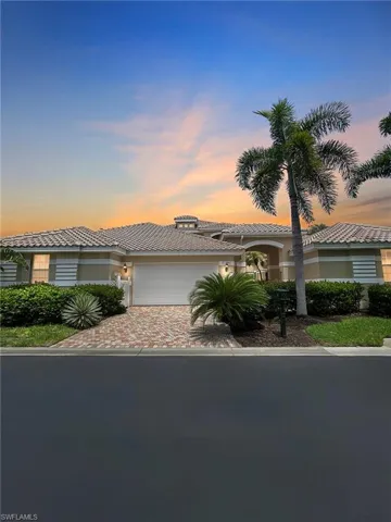 View of front of home with an attached garage, a tiled roof, driveway, and stucco siding