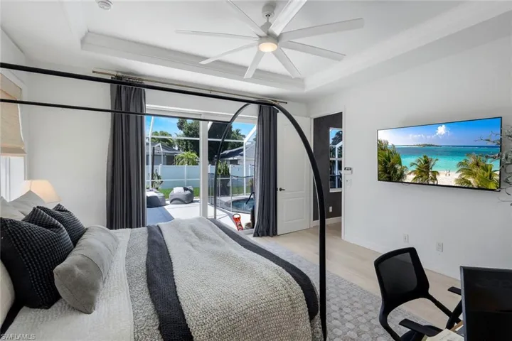 Bedroom featuring direct outdoor access to a pool area through glass sliding doors