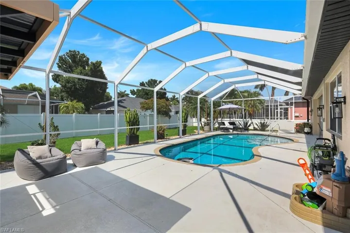 Screened lanai featuring a freeform swimming pool and integrated spa