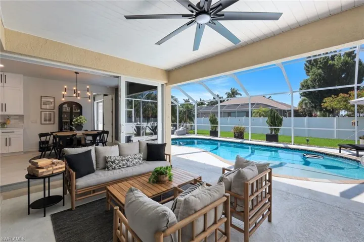 Screened-in patio with concrete flooring and a ceiling fan, opening to a private swimming pool