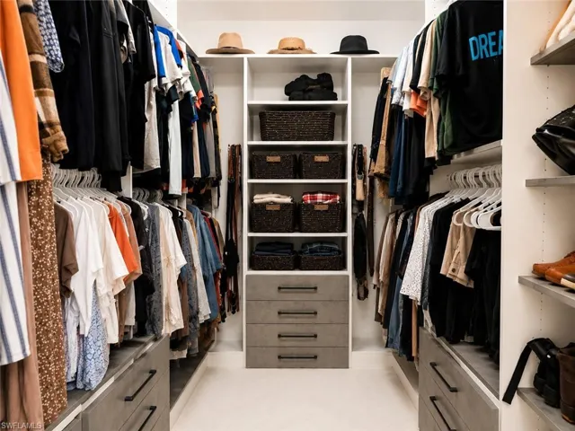 Custom closet system featuring extensive hanging space, integrated shelving, pull-out drawers, and dedicated open storage