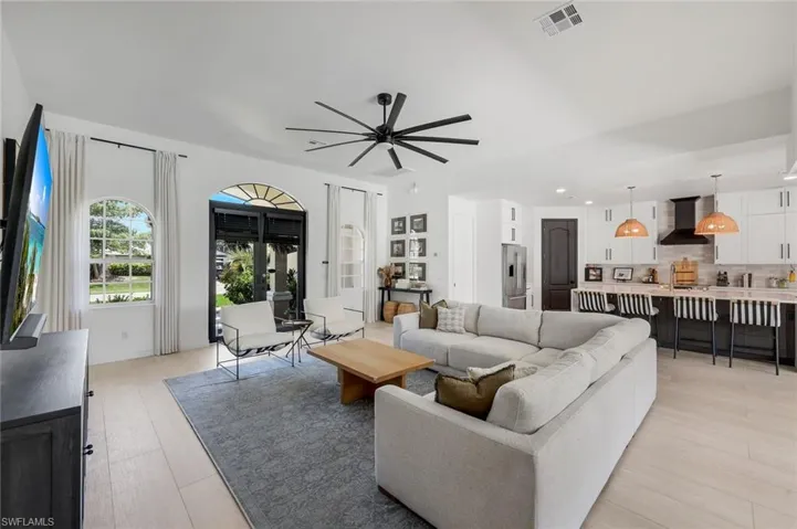 Open-concept living space featuring wood-finish flooring, recessed lighting, and an oversized ceiling fan