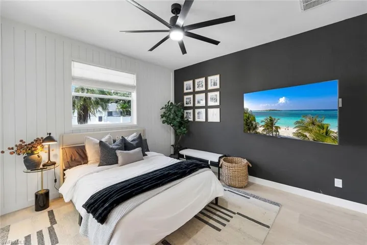 Bedroom featuring a contemporary ceiling fan, light wood-finish flooring, and a window with white blinds
