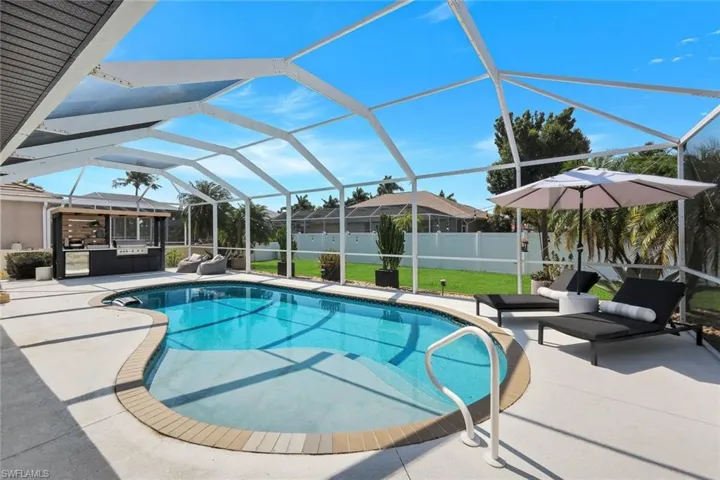 Screened outdoor swimming pool area with integrated outdoor kitchen