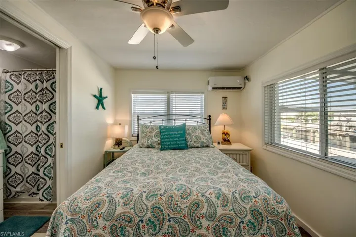 Bedroom featuring a ceiling fan and an AC wall unit