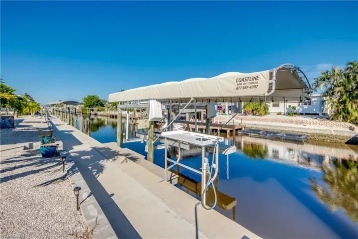 Dock featuring boat lift and a water view