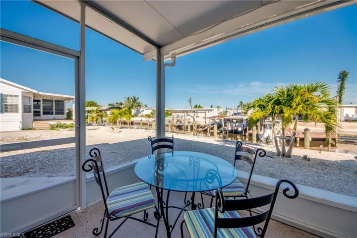 Balcony with a sunroom, boat lift, and a dock