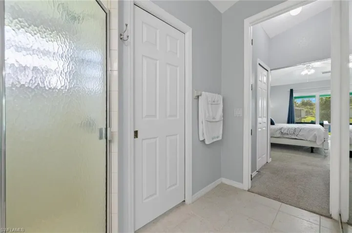 Bathroom featuring tile floors, a shower with door, and ceiling fan