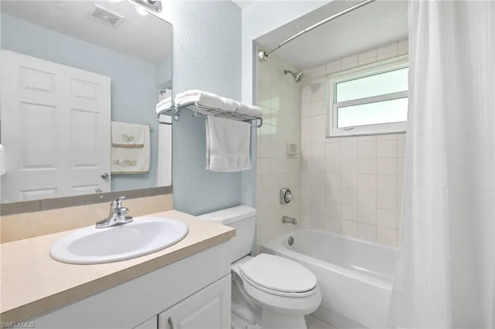 Full bathroom with shower / bath combination with curtain, toilet, and vanity