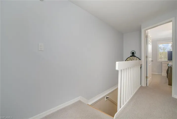 Hallway featuring light colored carpet