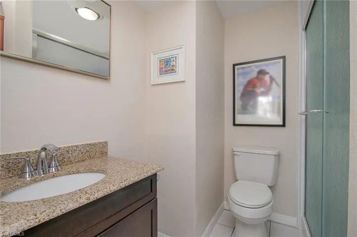 Bathroom with tile patterned flooring, vanity, toilet, and an enclosed shower