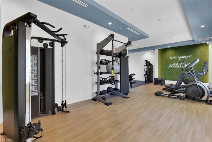 Exercise room featuring wood finished floors, recessed lighting, and baseboards